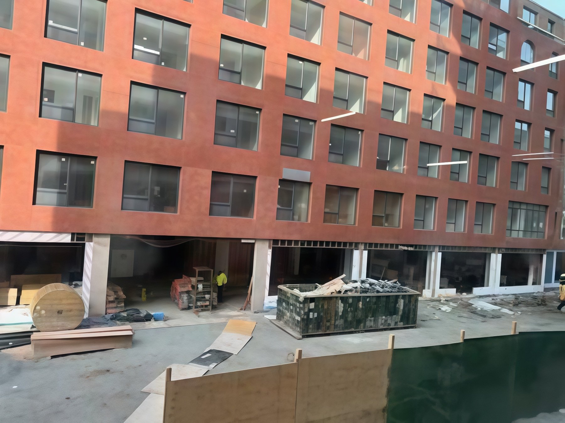 Exterior view of 395 Carroll Street under construction, highlighting new retail storefronts and residential floors as part of the Gowanus rezoning.