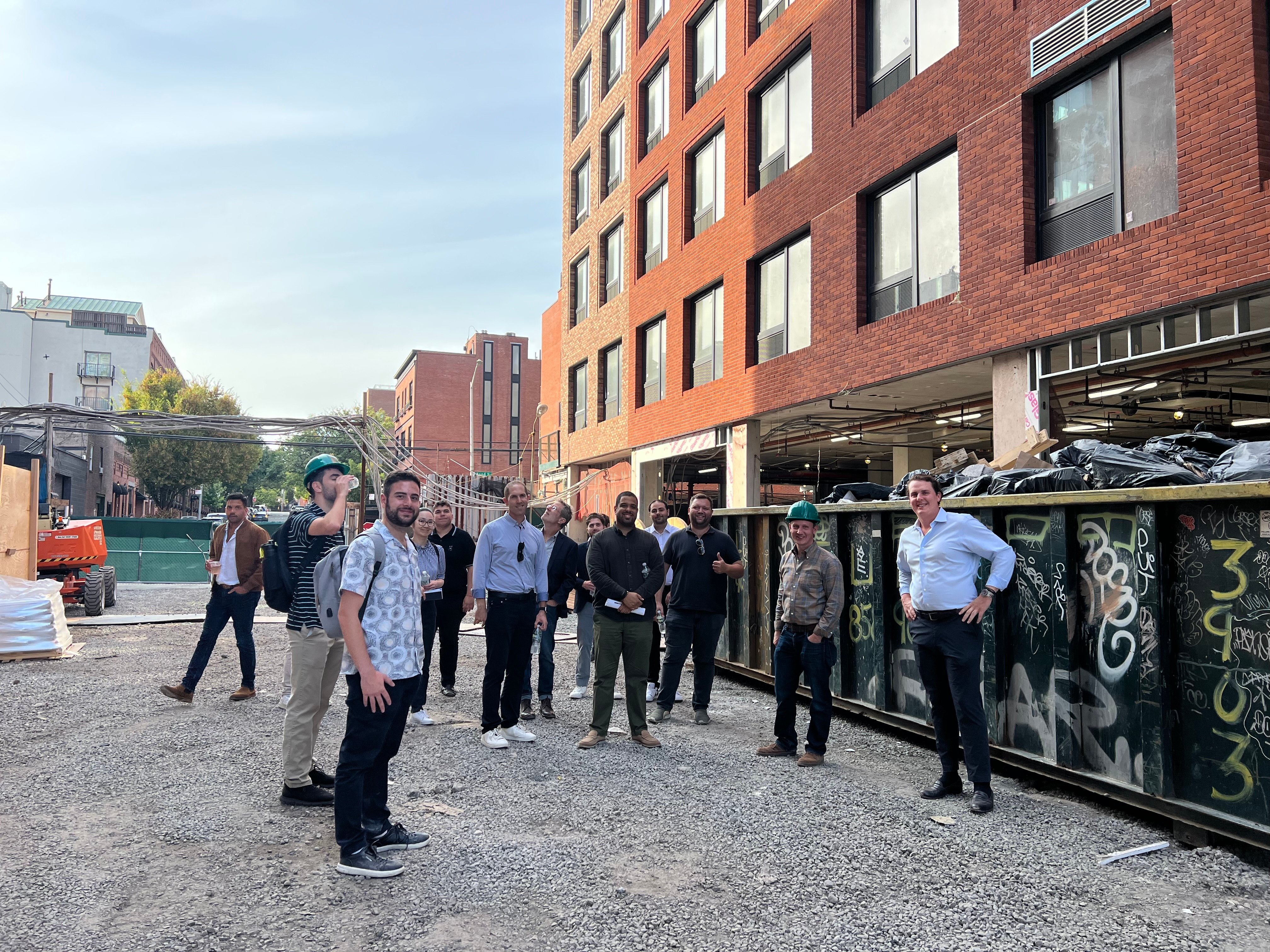 Group of REBNY members standing outside 395 Carroll Street in Gowanus during a site tour of active mixed-use developments.