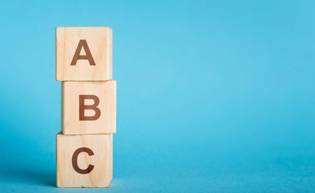 ABC letters of wooden blocks in pillar form on blue background