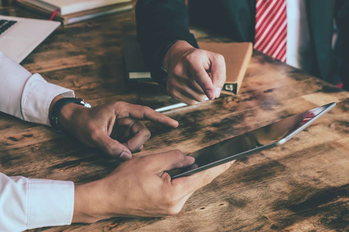 Close up of Business partners showing success with tablet