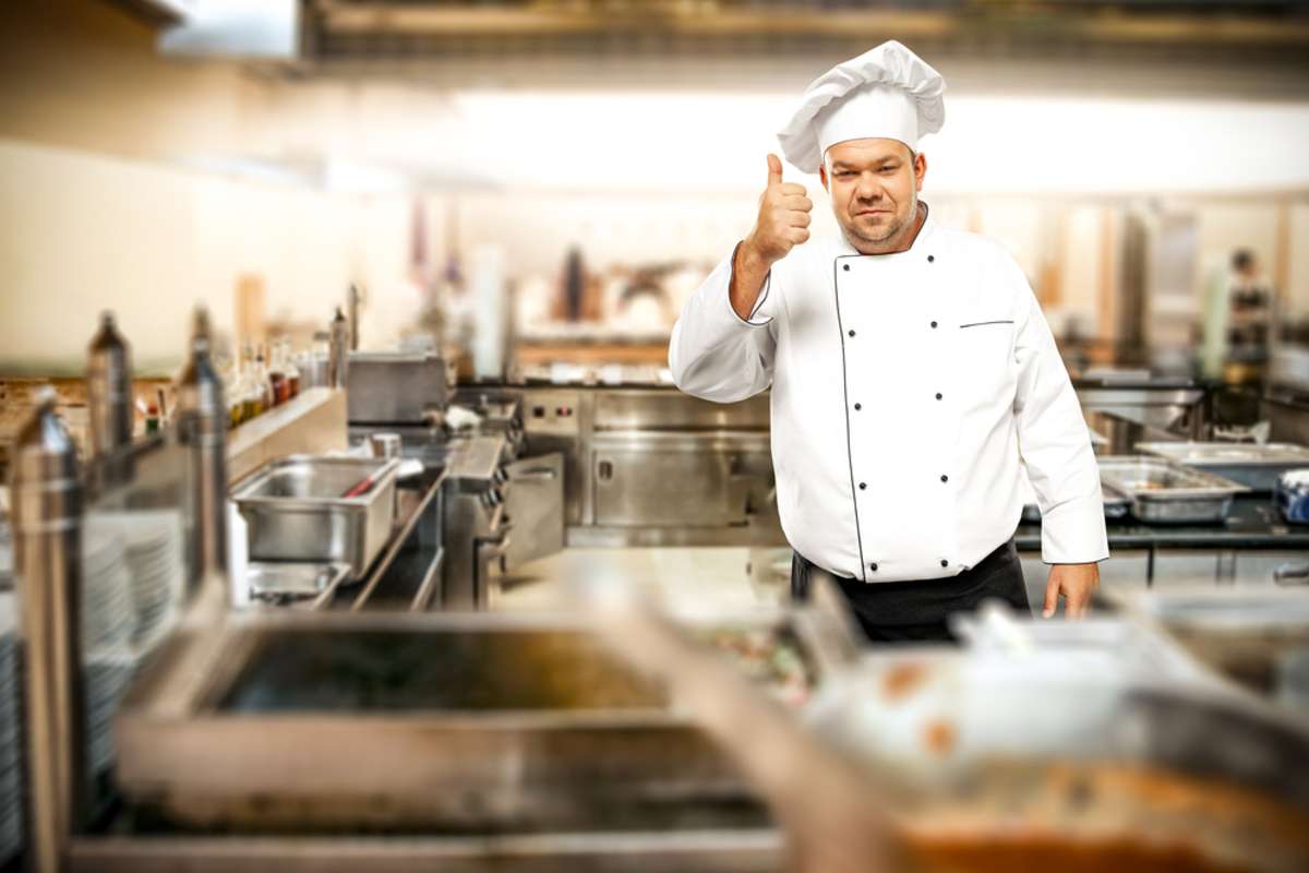 Cook chef in kitchen interior