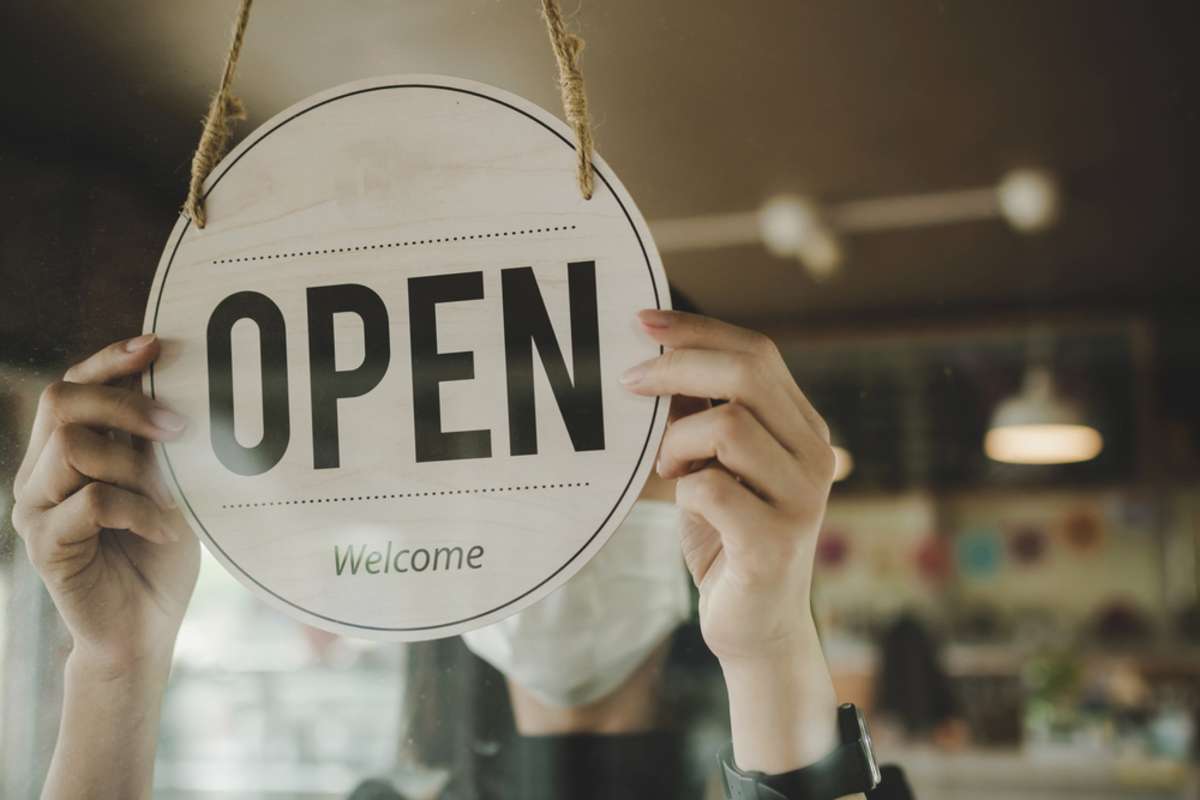 barista, waitress woman wearing protection face mask turning open sign board on glass door